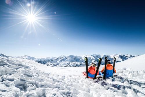 two people laying in the snow with skis at Appartementhaus Christophorus in Obertauern