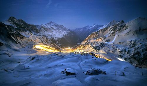 a view of a snowy mountain at night with lights at Appartementhaus Christophorus in Obertauern