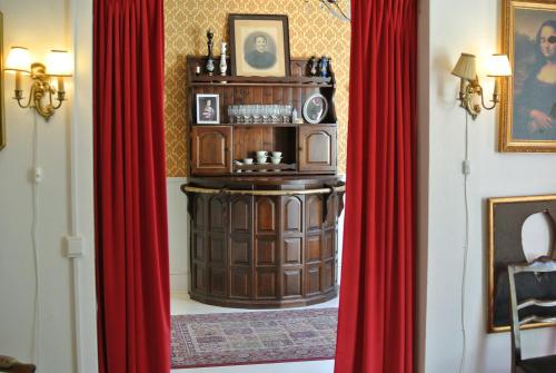 a room with red curtains and a wooden cabinet at Kungsgatans Gryta & Hotell in Malmö