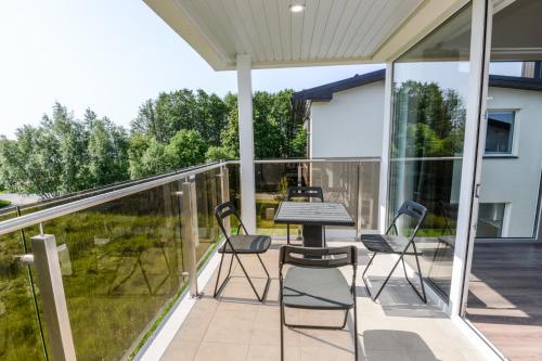 un patio con sedie e un tavolo su un balcone di Atsipūskit a Palanga