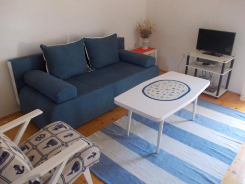 a living room with a blue couch and a table at Takoma Hvar in Hvar