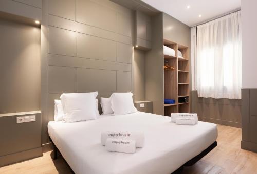 sypialnia z dużym białym łóżkiem z 2 pudłami w obiekcie Enjoybcn Patio de Gracia w Barcelonie
