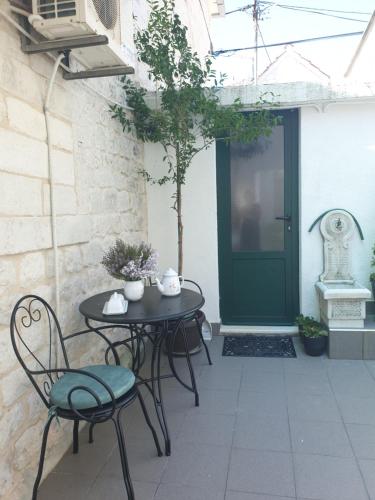 a patio with a table and chairs and a green door at LEMON TREE in Trogir
