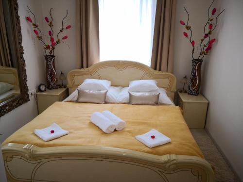 a bedroom with a bed with two towels on it at Kupola Apartman in Szeged