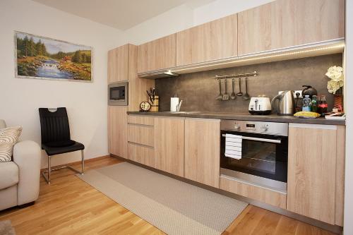 a kitchen with wooden cabinets and a stove at Apartmany Arber in Železná Ruda
