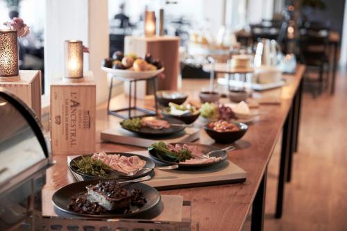 a long wooden table with plates of food on it at Hotel Skjern in Skjern