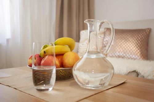a glass vase and a bowl of fruit on a table at Apartmany Arber in Železná Ruda