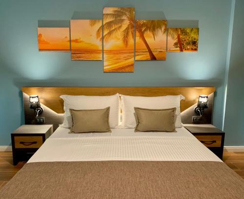 a bedroom with a bed with palm trees and a sunset at EKA Luxury Two-Bedroom Premium Apartment 2 in Durrës