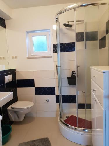 a bathroom with a shower and a toilet at Cozy apartments with seafront terraces in Omiš