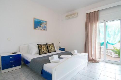 a bedroom with a bed and a large window at Shark Apartments in Skala Potamias