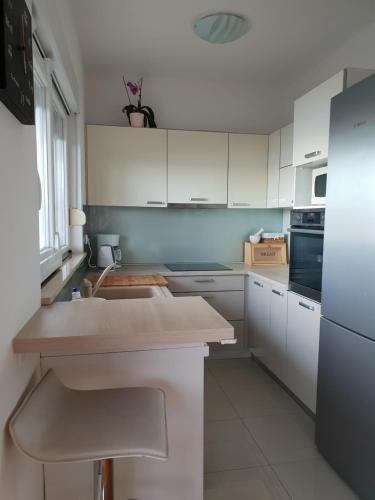 a kitchen with white cabinets and a counter top at Cozy apartments with seafront terraces in Omiš