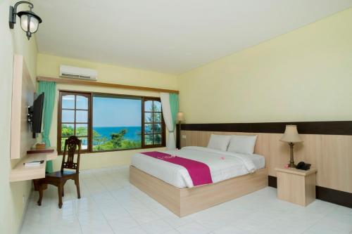a bedroom with a bed with a view of the ocean at Puri Saron Senggigi Hotel in Senggigi 