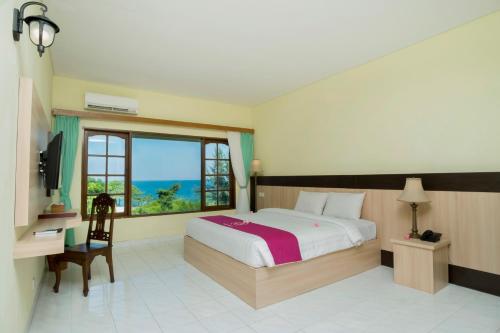 a bedroom with a bed with a view of the ocean at Puri Saron Senggigi Hotel in Senggigi