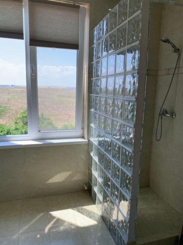 a shower with glass block walls and a window at La Cer in Constanţa