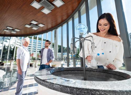 a woman standing in front of a sink in a building at Atlantida Boutique Hotel in Rogaška Slatina