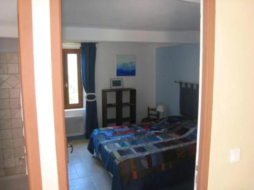 1 dormitorio con cama y ventana en Les Gîtes du Lac - Appartements, en Montauroux