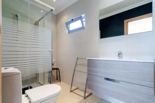 a bathroom with a toilet and a sink and a mirror at De Hofnar Apartments Albufeira in Albufeira