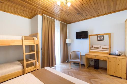 een slaapkamer met een bureau en een stapelbed bij Rambuje Resort in Lezhë