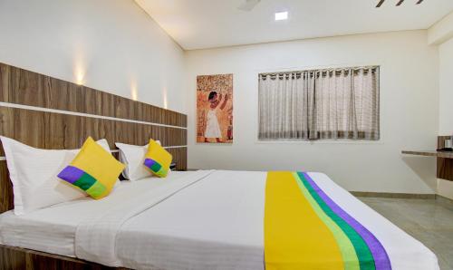 a bedroom with a large bed with colorful pillows at Treebo Lalaji's Executive in Aurangabad