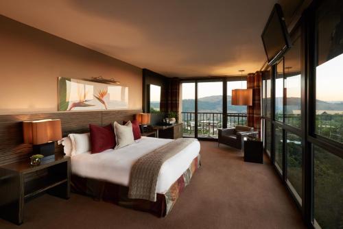una camera d'albergo con un grande letto e finestre di Thaba Eco Hotel a Johannesburg