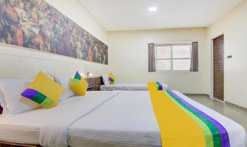 a bedroom with a large bed with colorful pillows at Treebo Lalaji's Executive in Aurangabad