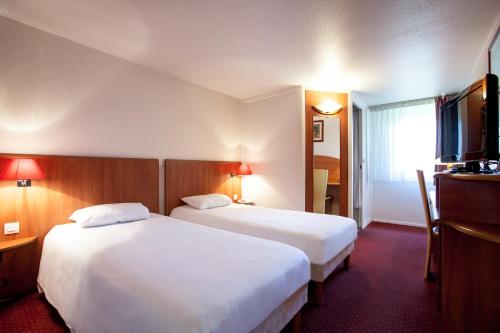 a hotel room with two beds and a flat screen tv at Hôtel inn design Sancé in Mâcon