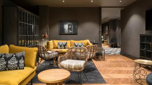 a living room with a yellow couch and chairs at Solo Sokos Hotel Turun Seurahuone in Turku