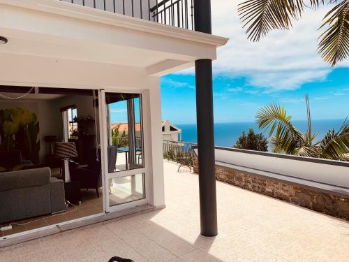 a view of the ocean from the balcony of a house at VILLA FELICIDADE in Arco da Calheta