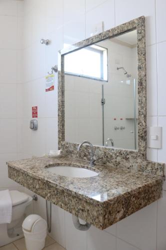 a bathroom with a sink and a mirror at Hotel Pousada Vale do Sol em Pompéia in Pompéia