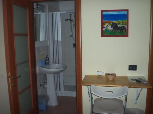 baño con lavabo y mesa con 2 sillas en B&B CARAVAGGIO SIRACUSA basic rooms at 200 Metres from Ortigia-, en Siracusa