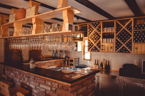 a kitchen with a bar with wine glasses at Vinska kuća na vinskoj cesti Zmajevac in Zmajevac