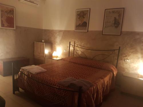sypialnia z łóżkiem z dwoma lampami i obrazami na ścianie w obiekcie Saint Martin's House w mieście Vigevano