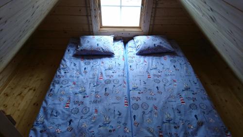 a bed in a tiny house with a window at Aadel Guesthouse in Pärnu