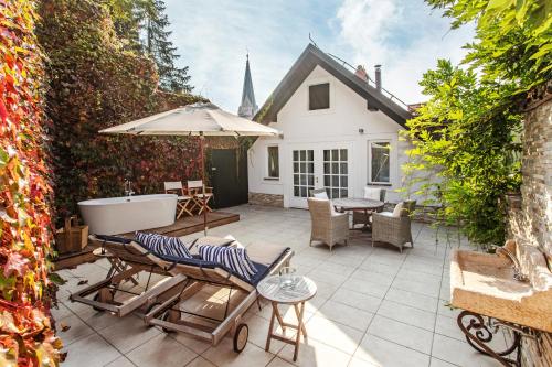 a patio with a tub and a table and chairs at Lesar Hotel Angel - Member of Hip Hotels in Ljubljana