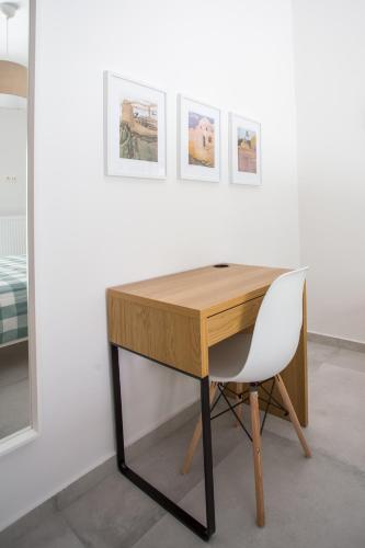 a desk with a chair next to a wall with pictures at Spacious Unique Luxurious Central in Thessaloniki