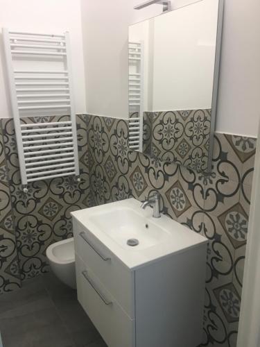een badkamer met een wastafel, een toilet en een spiegel bij Eolo in Deiva Marina