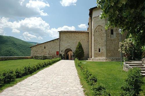PreciにあるAgriturismo Monti Sibillini Camperatoの庭のアーチ道のある大きな石造りの建物