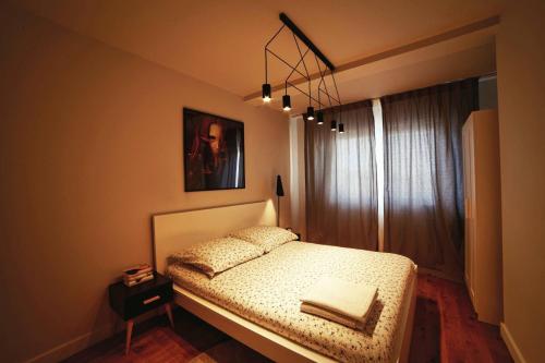 sypialnia z łóżkiem i żyrandolem w obiekcie One Apartment w mieście Śrem