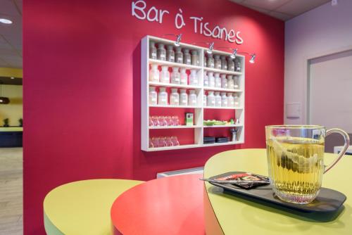 a restaurant with a drink on a table in a store at ibis styles Dax Centre in Dax