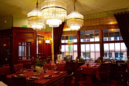 une salle à manger avec des tables et des lustres dans l'établissement Hotel des Tonneliers, à Strasbourg