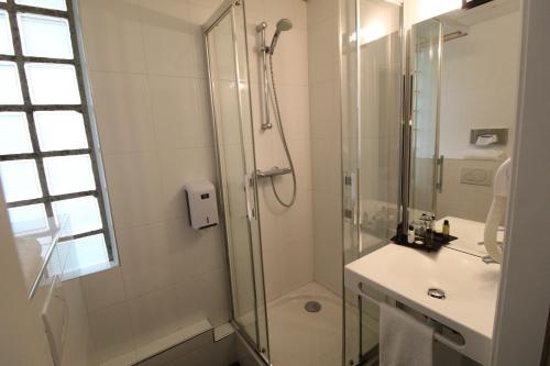 W łazience znajduje się prysznic i umywalka. w obiekcie Hotel des Tonneliers w Strasburgu