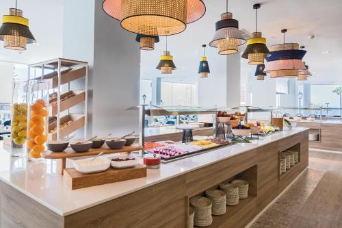 a buffet line with food on display in a restaurant at Occidental Fuengirola in Fuengirola