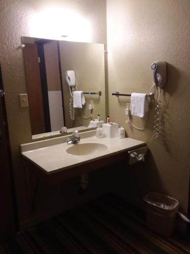 a bathroom with a sink with a mirror and a phone at Super 8 by Wyndham Grayling in Grayling
