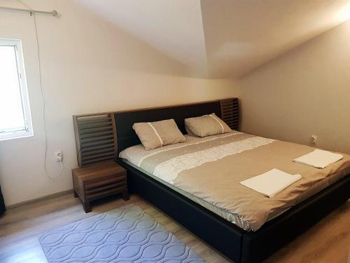 a bedroom with a large bed and a window at Vacation Home Naluka in Donji Morinj
