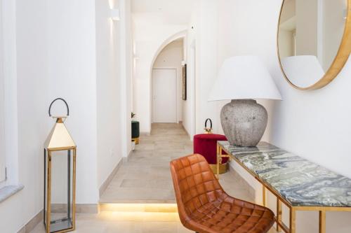 corridoio con tavolo, sedia e specchio di Divo Apartments - Spanish Steps a Roma