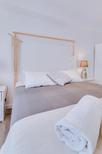 a white bedroom with a bed with white sheets at À da Avó -The Guesthouse in Faro
