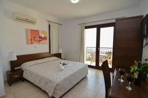 a bedroom with a bed and a table and a window at Palates Hotel in Droushia