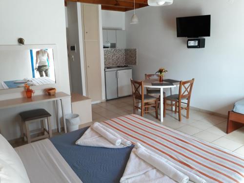 a living room with a kitchen and a table with chairs at Loutro Holidays in Loutro