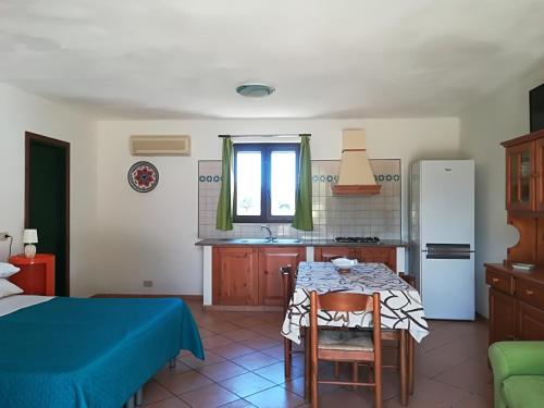 eine Küche mit einem Tisch und eine Küche mit einem Kühlschrank in der Unterkunft Casa Sirio in Favignana