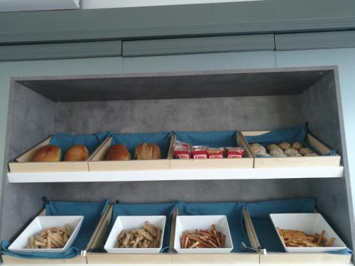 Un estante lleno de muchos tipos diferentes de pan. en 4-you Boutique, en Metamorfosi